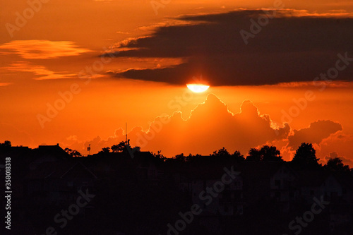 Amazing red sunset, clouds and the dark silhouette of the city