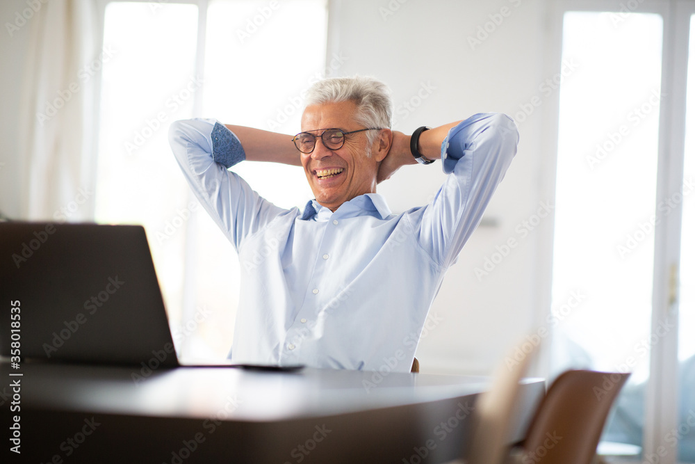 relaxed businessman looking at pop with hands behind head relaxed businessman looking at pop with hands behind head