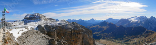 Panoramafoto vom Sass Pordoi in Richtung schneebedeckter Marmolata mit italienischer Flagge am linken Bildrand
