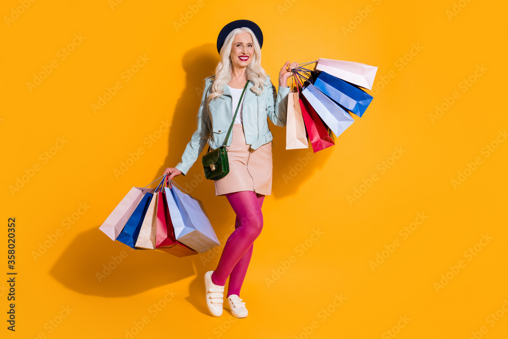 Full length photo of positive cheerful grey white hair old woman enjoy leisure time shopping hold bags wear good look skirt ink pantyhose headwear isolated bright shine color background Full length photo of positive cheerful grey white hair old woman enjoy leisure time shopping hold bags wear good look skirt ink pantyhose headwear isolated bright shine color background