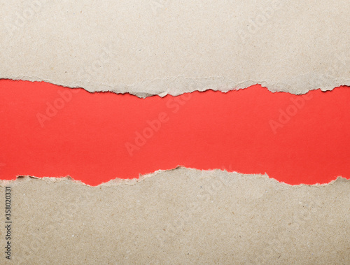 Wrapping paper with torn edges isolated with bright red paper background inside. Good paper texture Place for text.