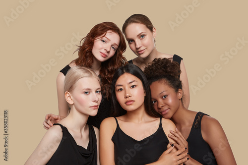 The real beauty exists in every corner of the world and is presented by women of all races. Group portrait of five beautiful ladies in black tops and with different skin and hair colour.