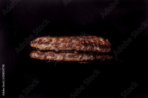 Meat for burger. Meat for burger on black background. Isolated meat for burger. Can be used for restaurant, cafe, food truck menu. Meat for ads. Meat for bigboards. Meat for cheeseburger or hamburger.