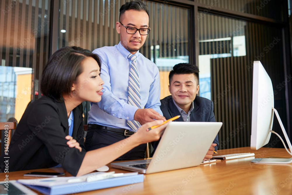Group of modern business people spending time together at office desk coworking on new project using latop Group of modern business people spending time together at office desk coworking on new project using latop