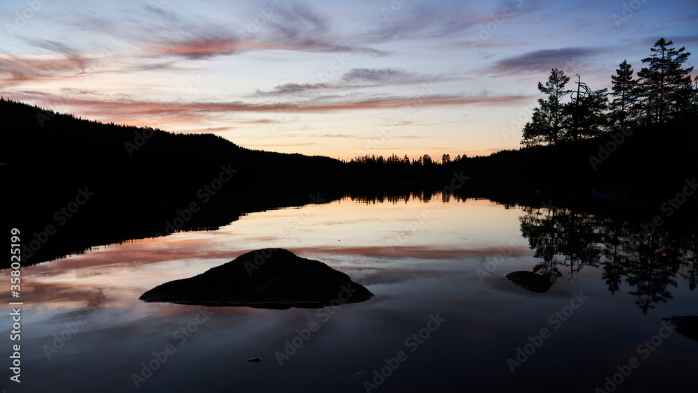 A beautiful lake and the sun has set. Bright colors and reflection in the water. shot in outside Oslo.
