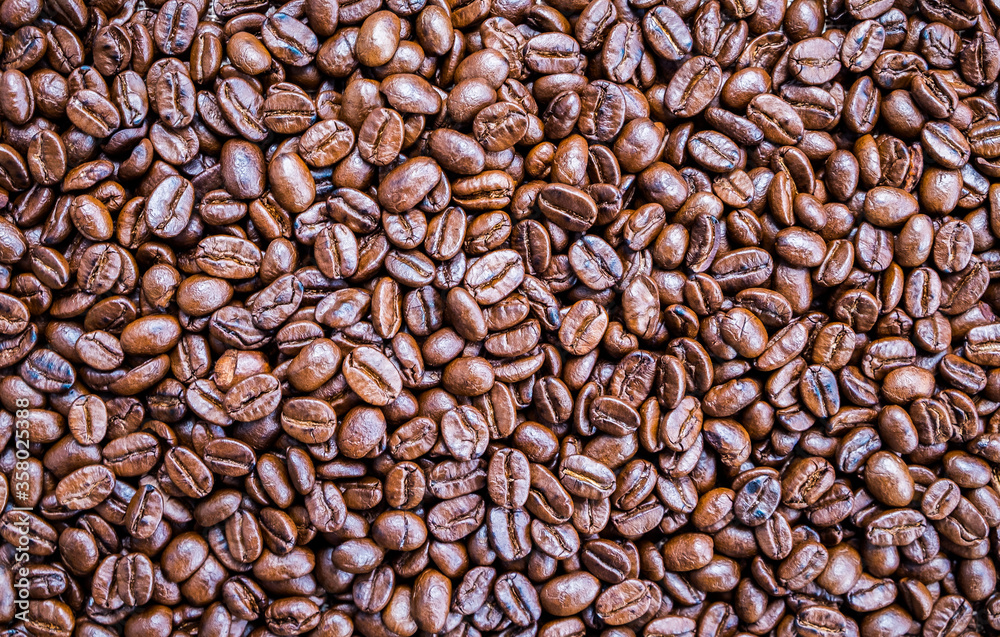 Brown roasted whole coffee beans background. Dark roast for your brewing method. Seed nature from above view. Group agriculture grain arabica. Photos from the top view.