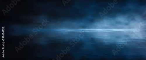 Dark empty scene, blue neon searchlight light, wet asphalt, smoke, night view, rays. Reflection on the water, night view. Liquid. 3d illustration. photo