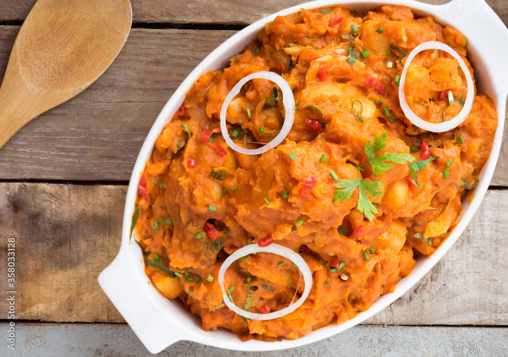 Φωτογραφία Close up view of a big white bowl of tasty yam pottage decorated with some green