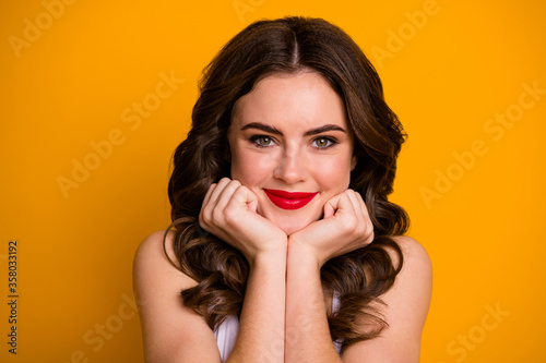 Closeup photo of pretty funny lady satisfied facial expression arms on cheeks cute dreamer flirty eyes look wear white casual tank-top isolated bright yellow color background