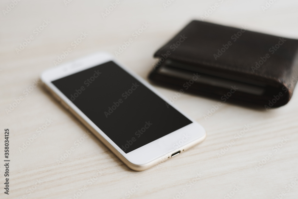Mobile phone and leather wallet with credit cards inside on wooden table. Mobile banking. Online money transfer Mobile phone and leather wallet with credit cards inside on wooden table. Mobile banking. Online money transfer