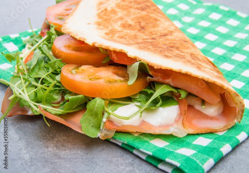 typical piadina romagnola with ham, cheese and rocket