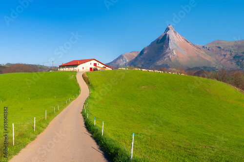 Rural landscape of farm in Goierri in Gipuzkoa against Txindoki mountain photo