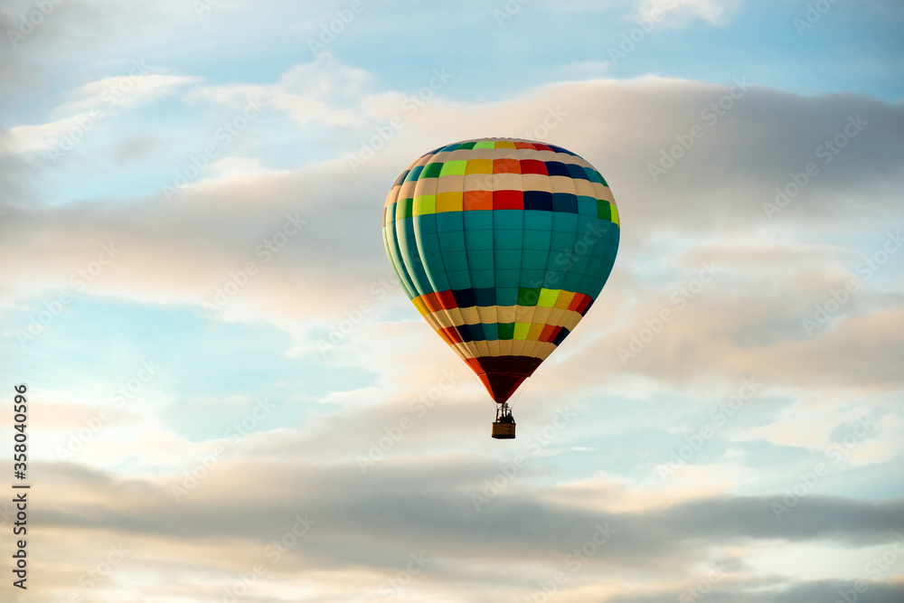 Obraz premium Colorful big hot air balloon flying against the cloudy sky