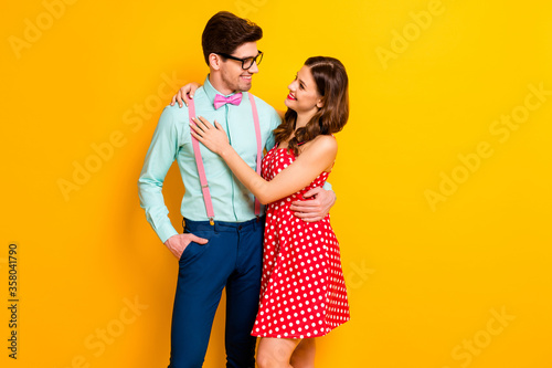 Portrait of passionate positive woman geek man enjoy 14-february date hug embrace cuddle wear red dotted dress blue shirt suspenders isolated over bright shine color background