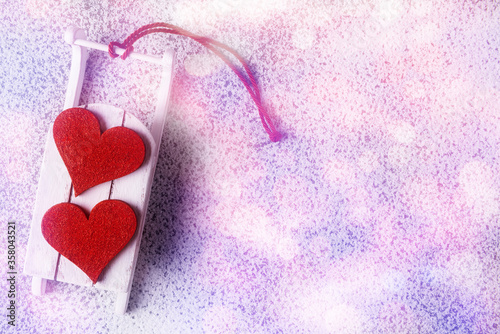 Two red hearts on white sleigh over snowy background with copy space. Valentine   s day concept