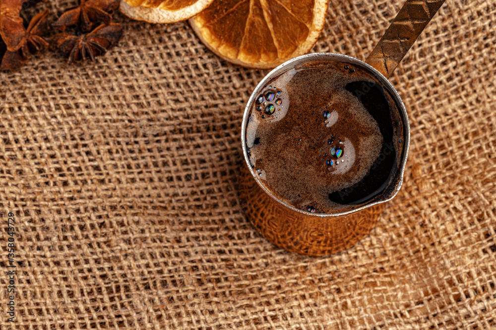 Shiny copper turk with brewed coffee on brown wooden table Shiny copper turk with brewed coffee on brown wooden table