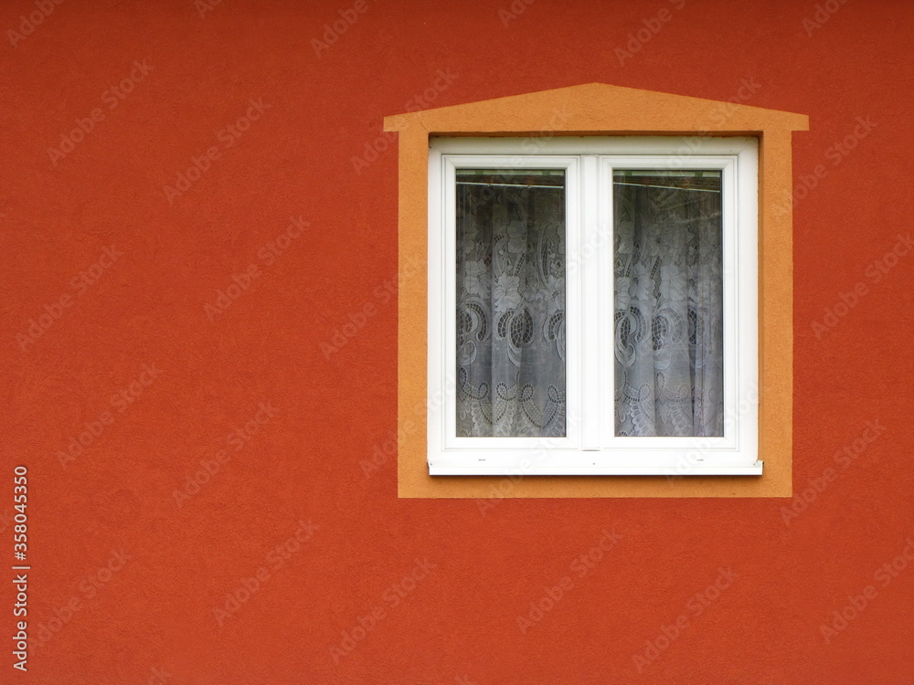 Window  with curtains and frame on orange wall