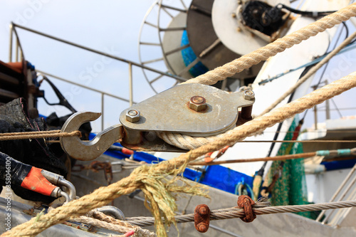 Fotografie old and rusty pulley ropes of a fishing boat