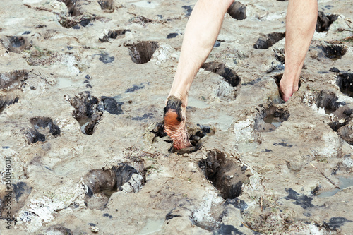 Feet sink into mud on shore of Lake Ebeyty, therapeutic mud, salt lake in Omsk region (Russia). photo