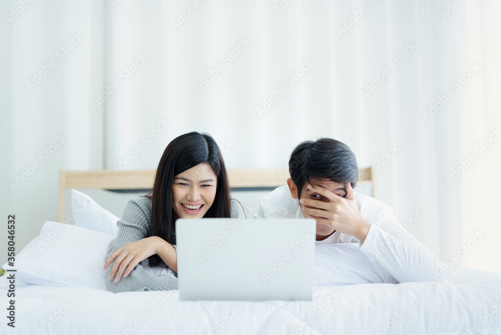 Lovers lie on their beds watching movies through notebook Modern Technology in their beds. Lovers lie on their beds watching movies through notebook Modern Technology in their beds.