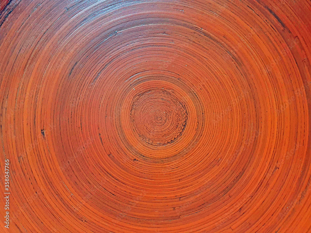 Woodwork painted in orange, texture of wooden circles, amber tint from sunlight