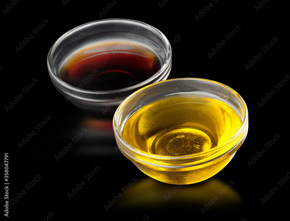 Aceite y vinagre sobre fondo negro. Oil and vinegar on a black background.