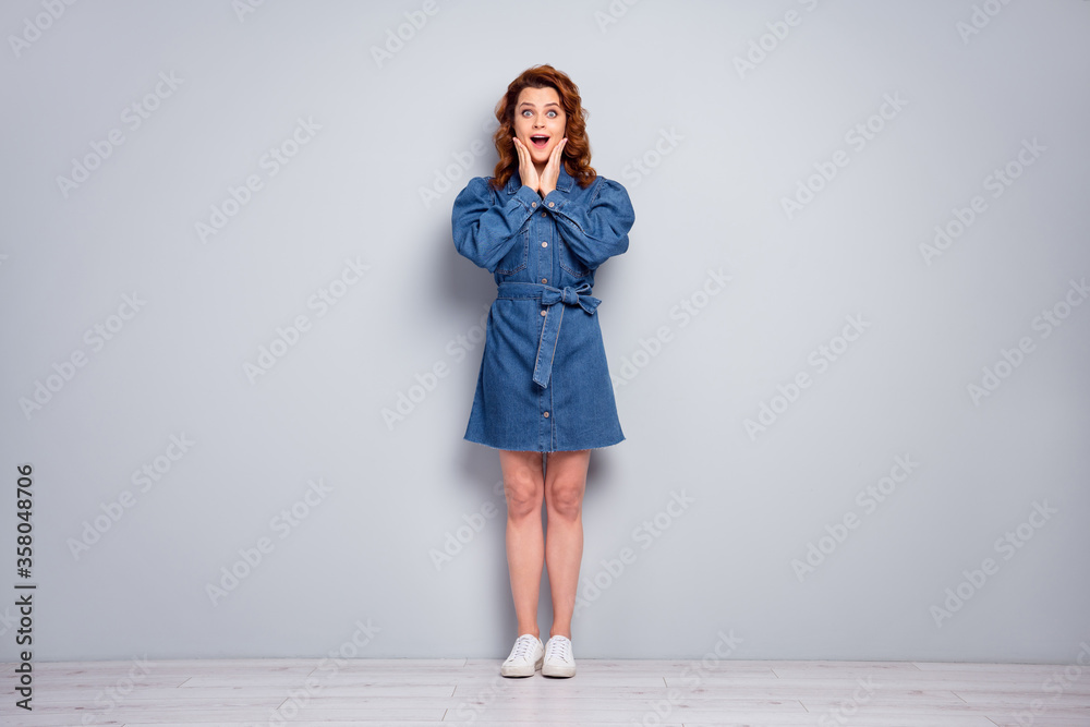 Full body photo of attractive crazy curly lady hold arms cheeks see sale discount advertisement wear casual blue denim short dress white shoes isolated grey color background Full body photo of attractive crazy curly lady hold arms cheeks see sale discount advertisement wear casual blue denim short dress white shoes isolated grey color background