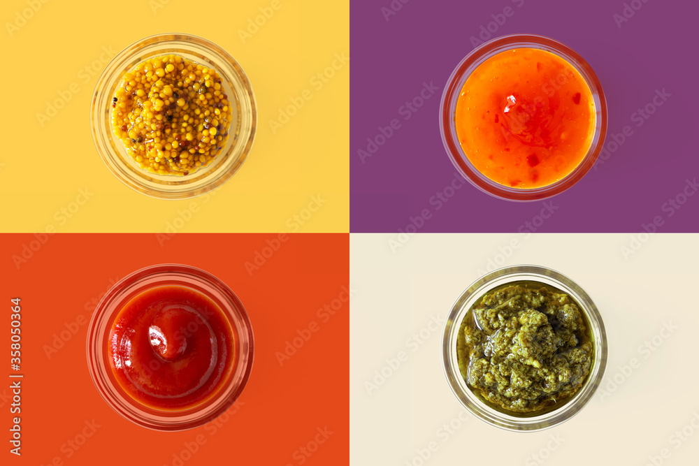 Φωτογραφία Mustard with whole grain, hot sweet chilli pepper sauce, ketchup and pesto in glass bowl on bright colorful background, top view