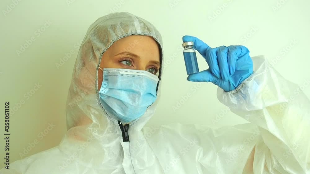 virologist woman in chemical protection mask ,glasses and gloves holding potential vaccine at the lab virologist woman in chemical protection mask ,glasses and gloves holding potential vaccine at the lab