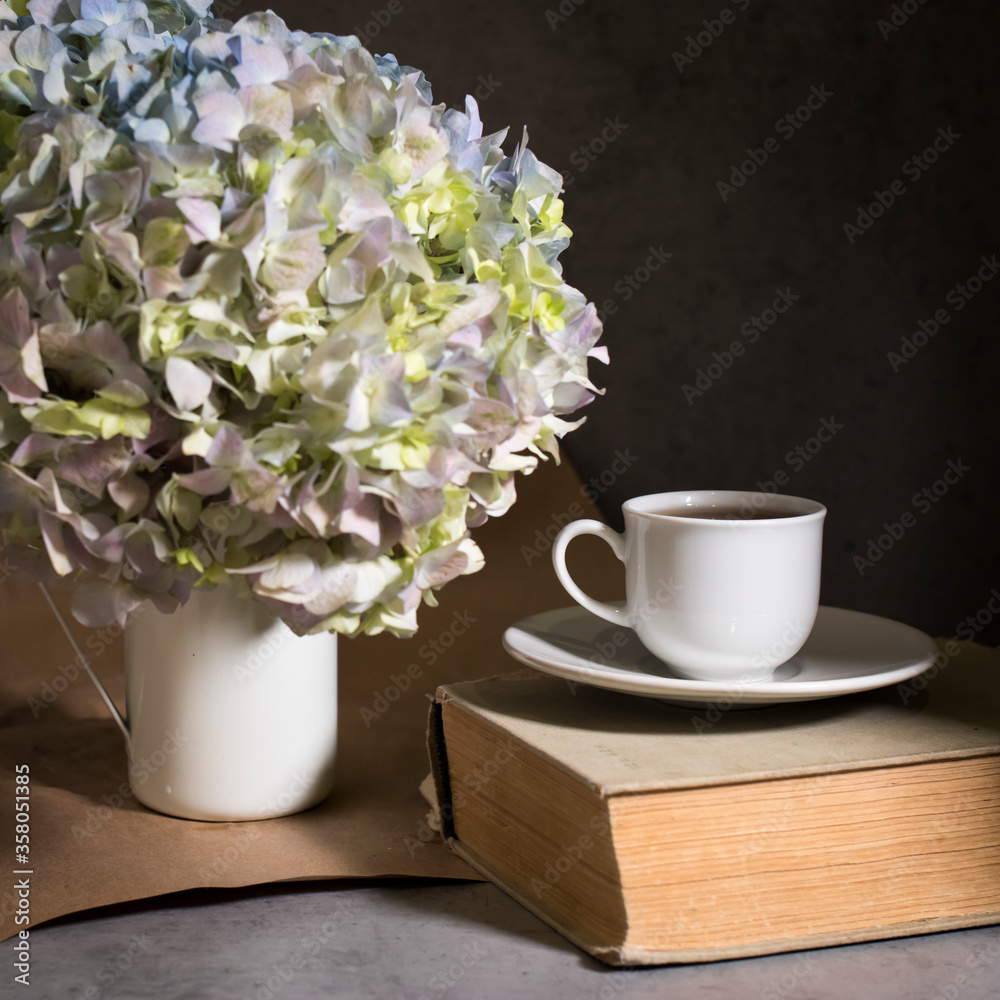 A branch of green pastel hydrangeain an enameled mug instead of a vase on a on a gray craft vintage background. Copy space A branch of green pastel hydrangeain an enameled mug instead of a vase on a on a gray craft vintage background. Copy space