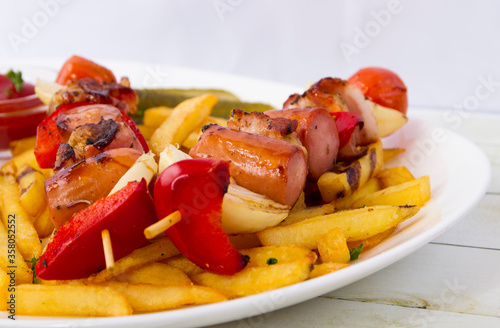 Grilled sausage skewers with french fries top view side view close up