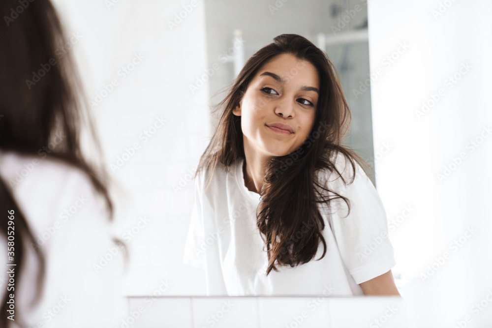 Photo of cheerful nice woman smiling while looking at mirror Photo of cheerful nice woman smiling while looking at mirror