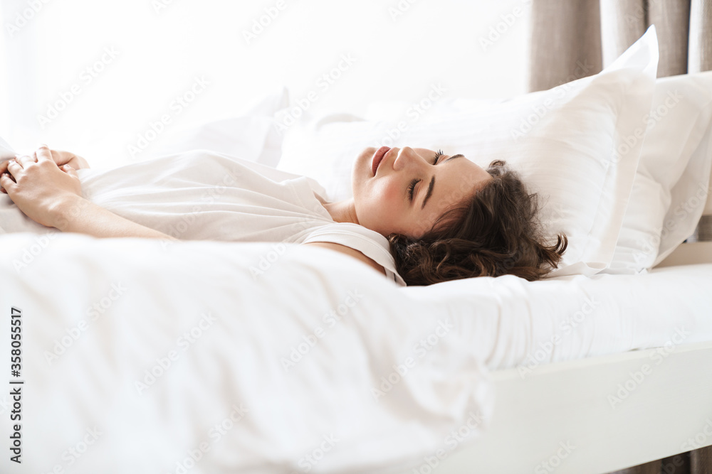 Photo of pretty beautiful woman with curly hair sleeping in bed at home Photo of pretty beautiful woman with curly hair sleeping in bed at home