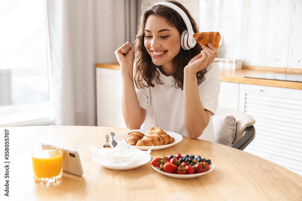 Photo of woman watching movie on mobile phone while having breakfast Photo of woman watching movie on mobile phone while having breakfast