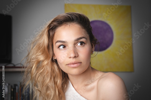 Very handsome female portrait shot at home. Beautiful girl with big eyes and lips looking