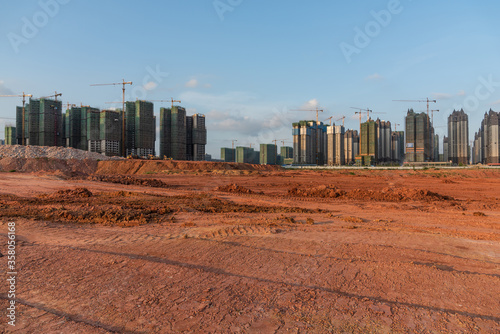 Building under construction and wide dirt ground