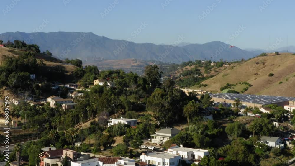 Helicopter dropping water on California brush fire, Los Angeles suburb, aerial view Helicopter dropping water on California brush fire, Los Angeles suburb, aerial view