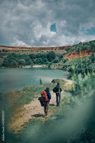 Fototapeta Naklejka Na Ścianę i Meble -  Two men with backpacks searching place for camping.