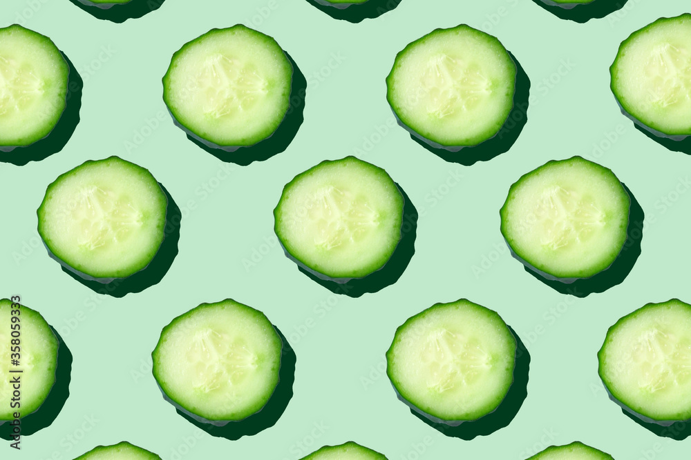 Regular seamless pattern of cucumber slices on a  pastel mint background.Photo collage,hard light, shadow,pop art design. Food blog, vegetable background. Printing on fabric, wrapping paper.Top view. - obrazy, fototapety, plakaty 