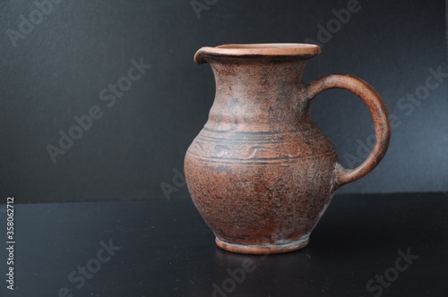 Clay jug with a pattern on a black background