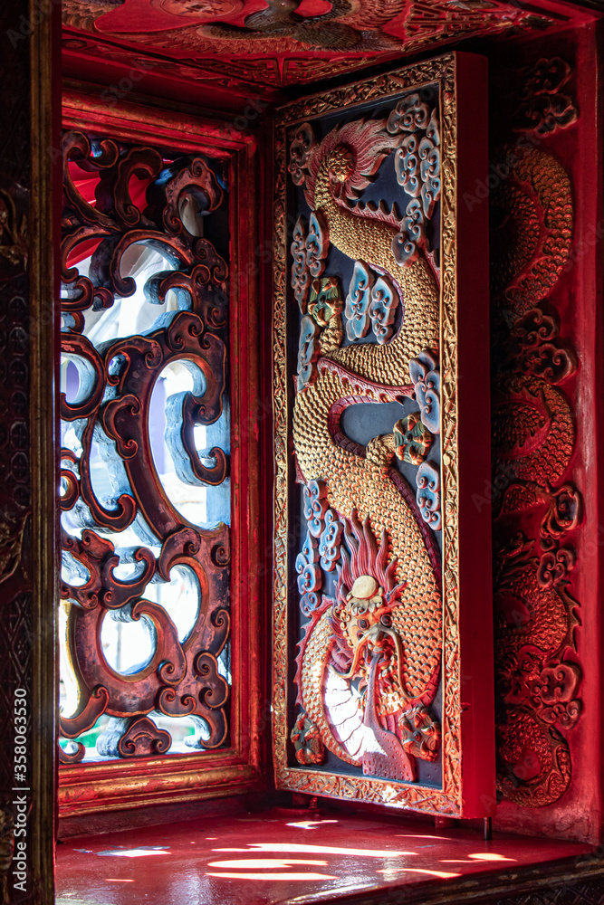 Carved shutters in an oriental temple. Richly decorated shutters with dragon theme, Chinese Buddhist monastery. Carved shutters in an oriental temple. Richly decorated shutters with dragon theme, Chinese Buddhist monastery.