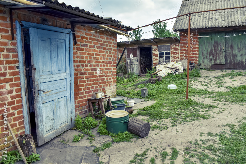 Poor rural residential courtyard with brick buildings in Ukraine. The concept of life in the Ukrainian village, a simple old dwelling Poor rural residential courtyard with brick buildings in Ukraine. The concept of life in the Ukrainian village, a simple old dwelling