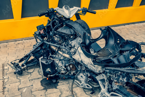 Vehicle, tricycle, after an accident. A burned motorcycle near the workshop. Mechanism metal covered in ashes. Various motorcycle mechanisms are visible. Gears, springs, tanks, skeleton, traction. photo