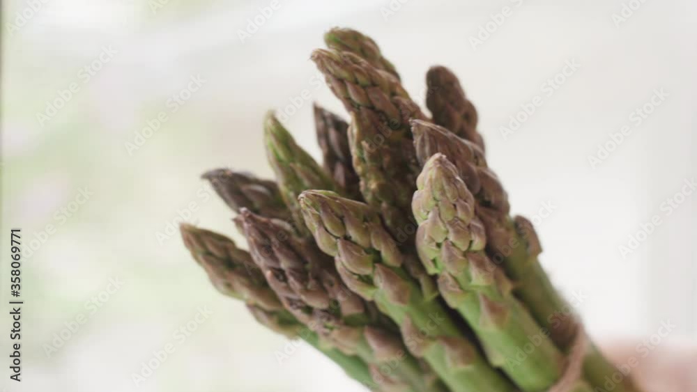 Bunch of green asparagus in the young farmer's hand. Close up shot. Bunch of green asparagus in the young farmer's hand. Close up shot.