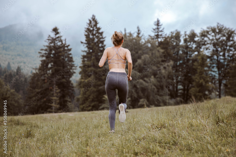 Young fitness woman running at forest trail Young fitness woman running at forest trail