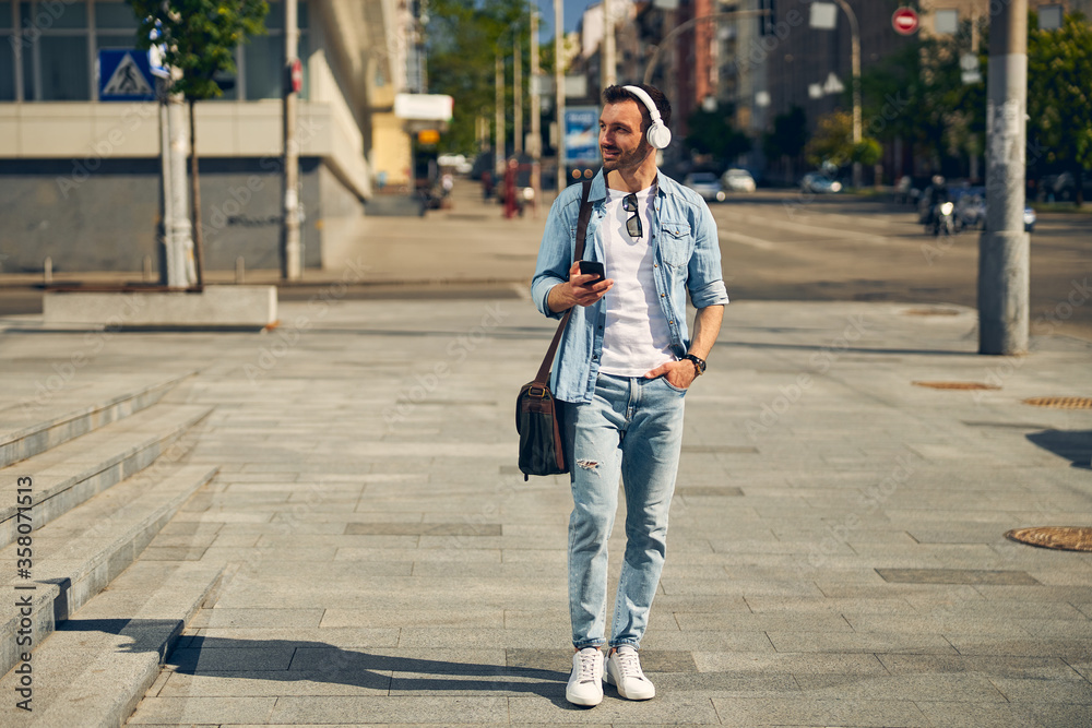 Delighted young male walking in the street Delighted young male walking in the street