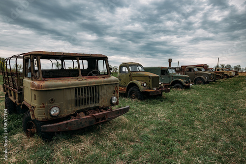 Old rusty truck at abandoned overgrown industrial area