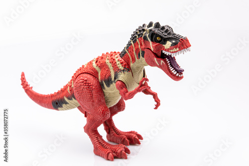 close-up of a colorfull plastic figurine of a tyranosaurus isolated on a white background