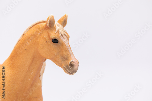 close up of a brown plastic horse head isolated on a white background