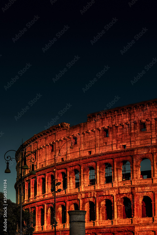 Front view of wonderful ancient Colosseum at blood reddish night illumination, Rome, Italy, details, closeup